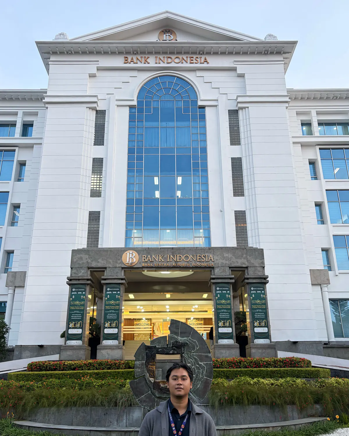 Wildan stands in front of the Bank Indonesia West Java office facade.